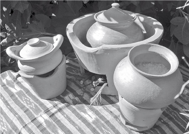 Thai clay pots for cooking that double as hot–pressing implements, sitting on top of furnaces.